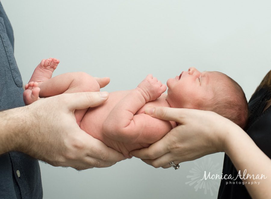 Sleepy Baby Girl In Parents Hands Photo