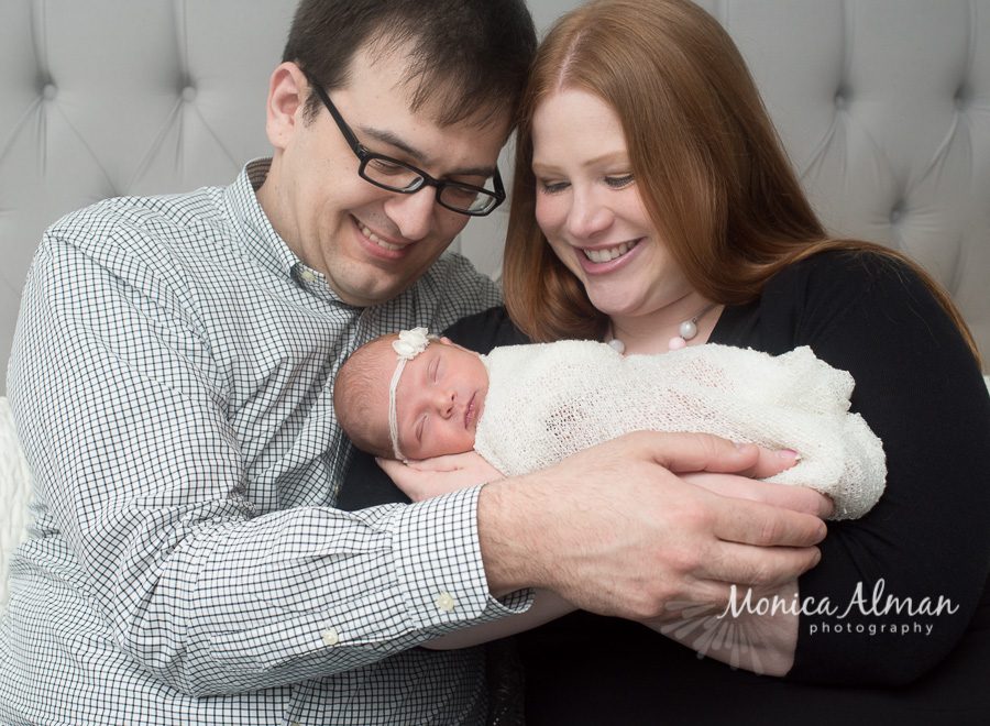 Beautiful Newborn Baby Girl Mom and Dad Looking At Baby Photo