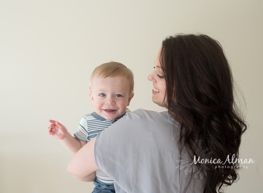 Baby Boy Milestone Session Mom Looking at Baby Photo