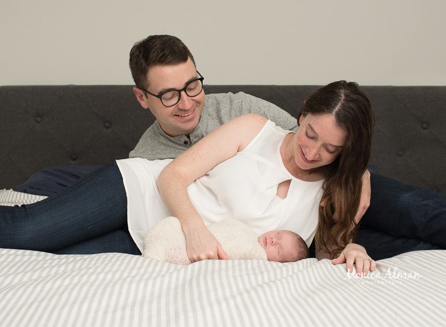 neutral portrait newborn session mom and dad looking at baby photo