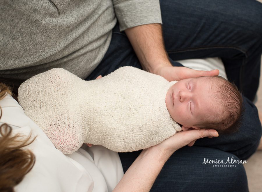 neutral portrait newborn session unique image of baby in parents arms photo
