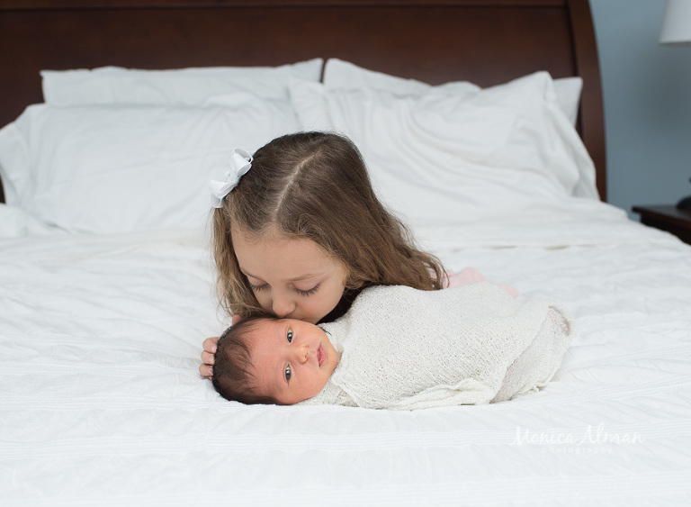 Baby brother sister kissing newborn photo