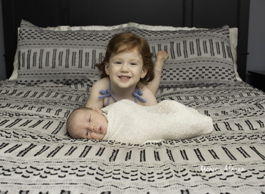 big sister smiling with little baby brother