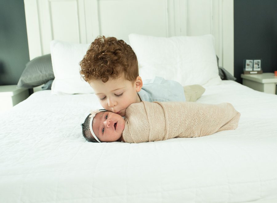 brother kissing new baby girl picture