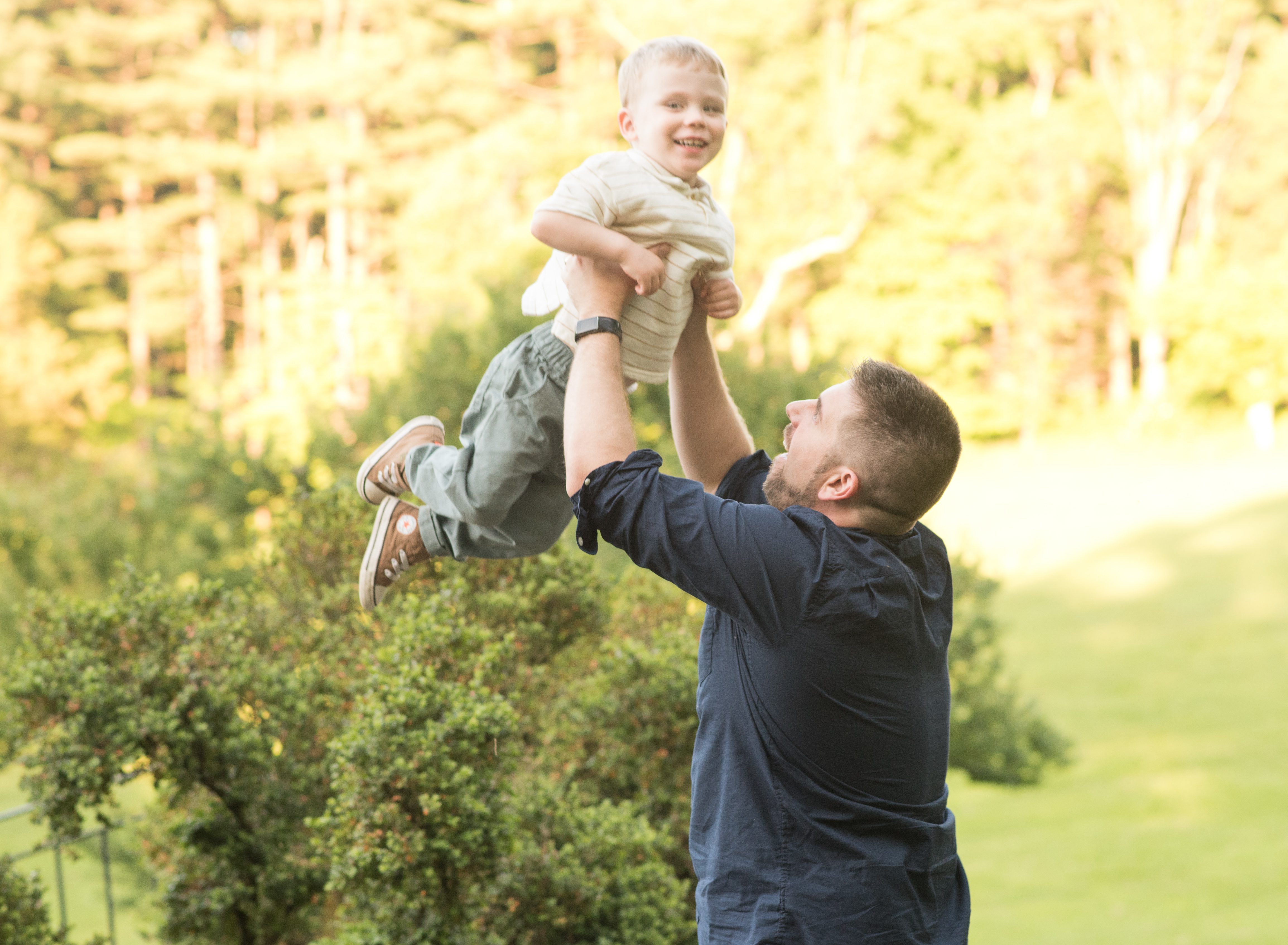 dad throwing boy in the air photo