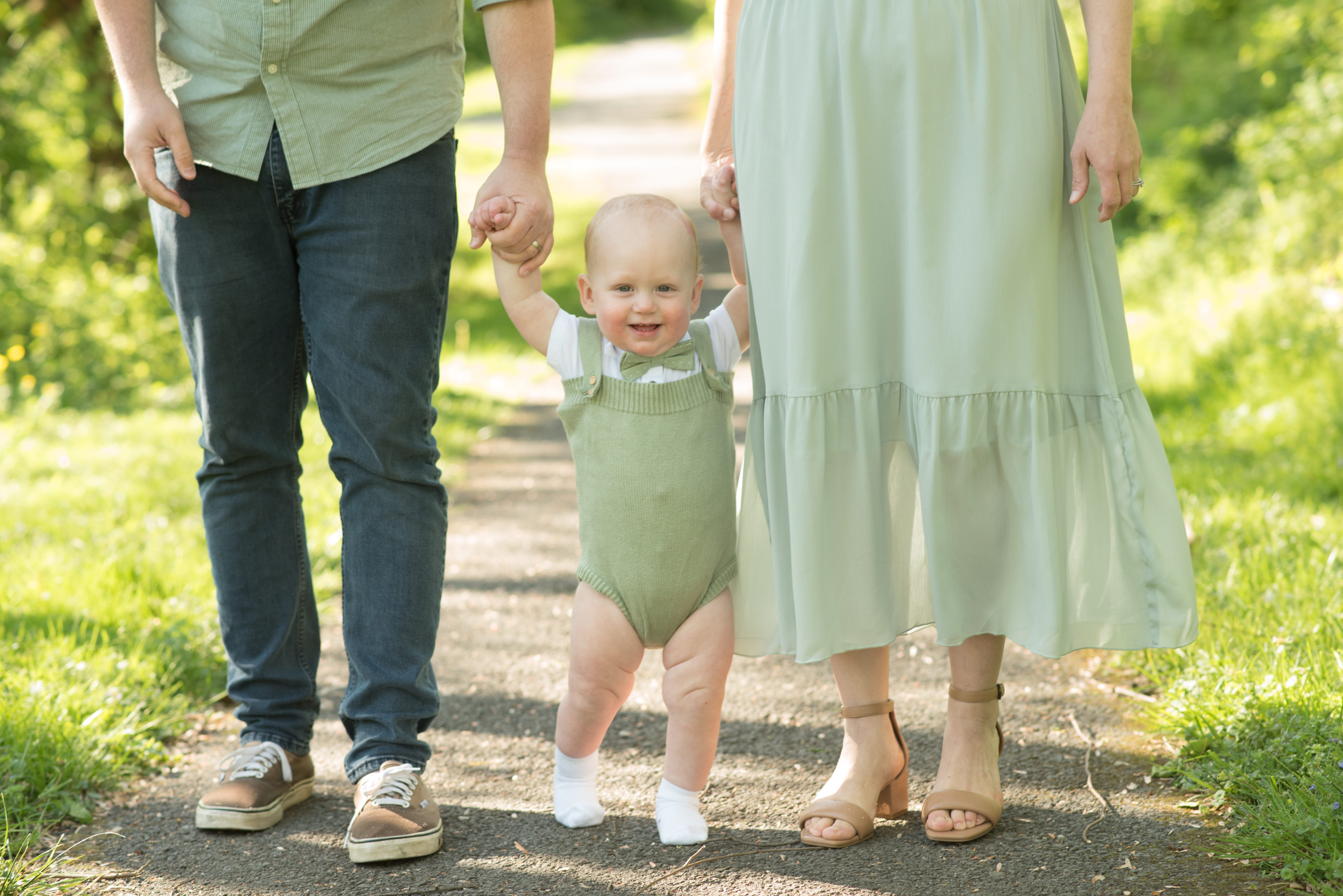 baby boy standing with parents in the Kentlands in Gaithersburg, Maryland