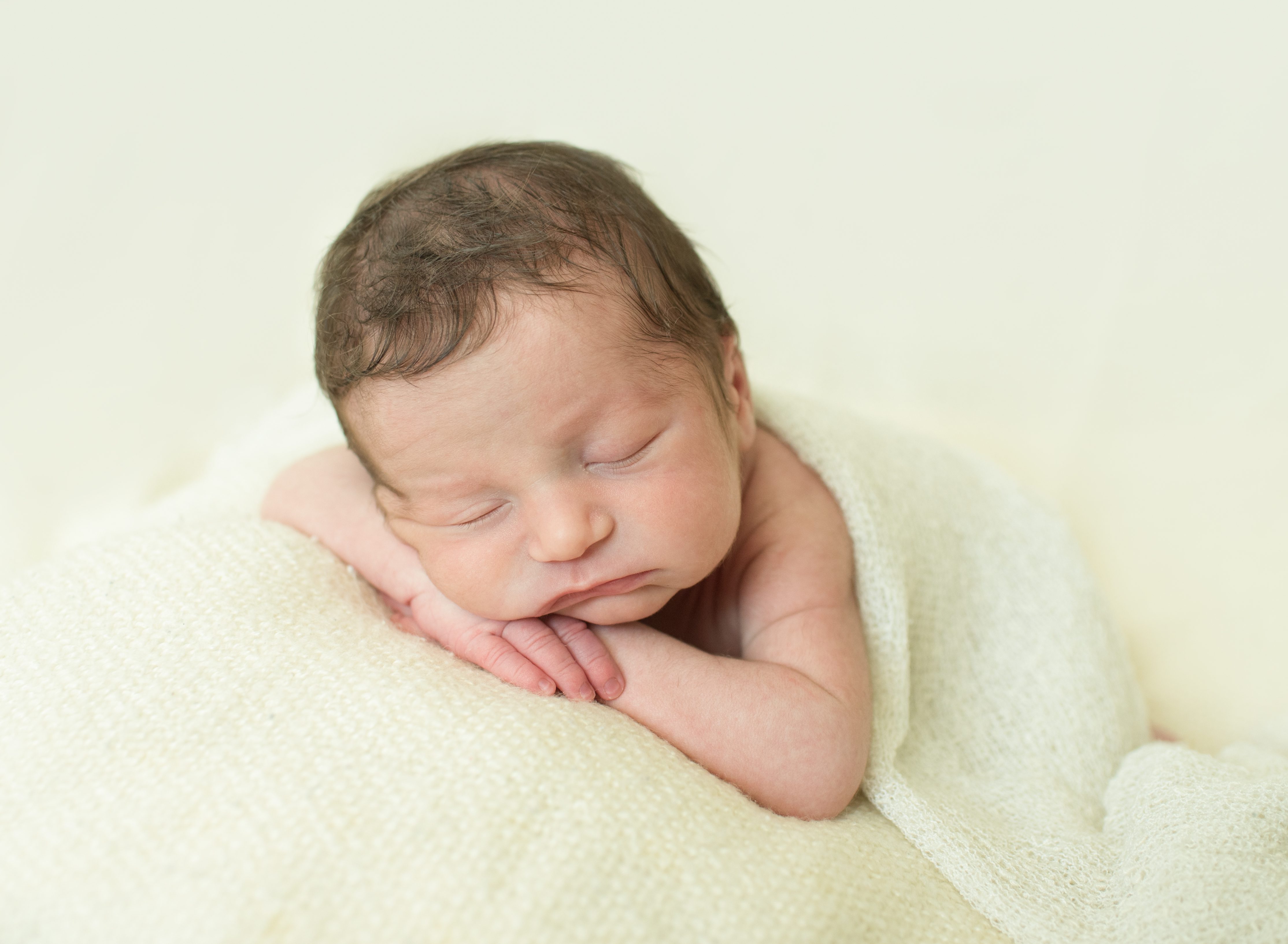 posed baby on cream blanket