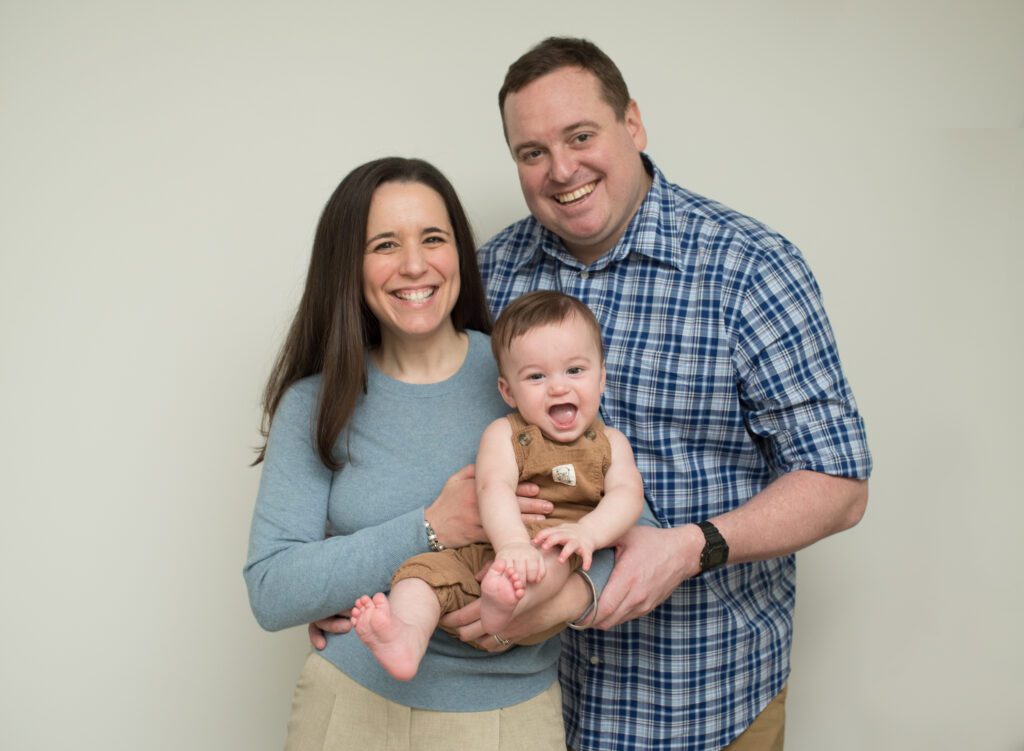 parents posing with 6 month old baby photo