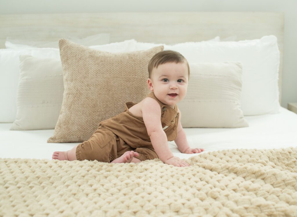 baby sitting on big bed photo