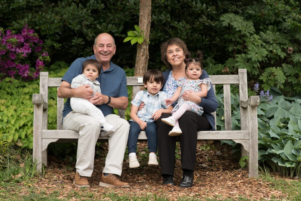 grandparents with their grandkids sitting on a bench photo